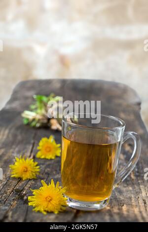 Fond de thé de pissenlit, remède à base de plantes. Thé de pissenlit, fleur, feuilles et racine sur bois Banque D'Images