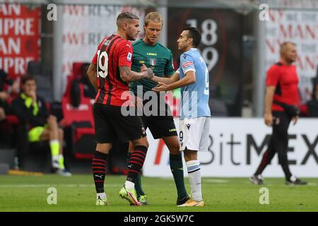 Milan, Italie, 12 septembre 2021. Theo Hernandez de l'AC Milan et Pedro de SS Lazio secoue les mains devant l'arbitre Daniele Chiffi suite à une altercation entre les deux lors de la série Un match à Giuseppe Meazza, Milan. Le crédit photo devrait se lire: Jonathan Moscrop / Sportimage Banque D'Images