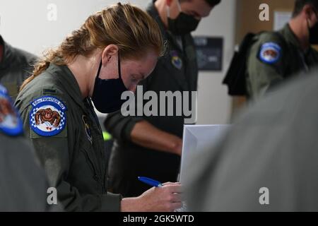 Le 1er lieutenant Amanda Cannon de la US Air Force, 58e Escadron d'avions F-35A pilote étudiant Lighting II, se prépare pour un vol le 10 août 2021 à la base aérienne d'Eielson, en Alaska. Avant chaque vol, les pilotes sont informés des conditions météorologiques et de toute autre information importante pour assurer un vol sûr et réussi. Banque D'Images