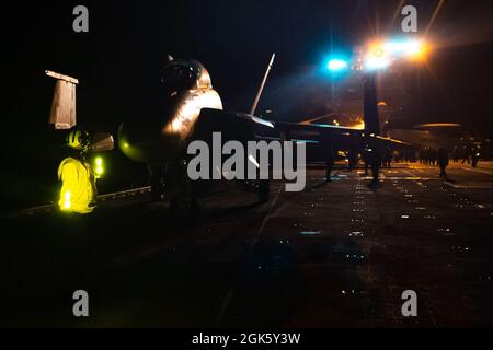 210810-N-OL611-2048 OCÉAN PACIFIQUE (le 10 août 2021) Un marin affecté au porte-avions de la classe Nimitz USS Carl Vinson (CVN 70) dirige un aéronef pendant les opérations de vol de nuit, le 10 août 2021. Vinson participe à l’exercice à grande échelle 2021, une formation intégrée à l’échelle mondiale qui démontre la capacité de la marine américaine à déployer une force précise, létale et écrasante sur trois commandes de composantes navales, cinq flottes numérotées et 17 fuseaux horaires. Banque D'Images