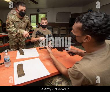 Tech. Sgt. Richard Thomas (à gauche), NCO en charge des armes de combat pour le 88e Escadron des forces de sécurité, travaille avec le sergent d'état-major. Andrew Young (au centre) et Matthew Lennon, de première classe d'Airman, tous deux avec le 88e Escadron de communications, à bord du fusil M4 pendant l'entraînement du 11 août 2021, au centre d'entraînement de Warfighter sur la base aérienne Wright-Patterson, Ohio. Banque D'Images