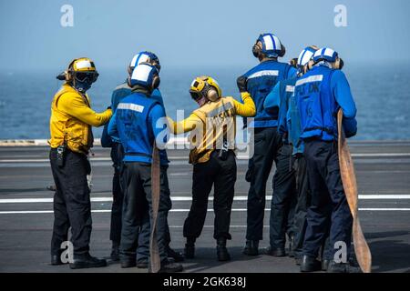 210812-N-DW158-1034 MER D'ARABIE (AOÛT 12, 2021) – les marins se préparent à combattre un incendie simulé lors d'un exercice de masse sur le pont de vol du porte-avions USS Ronald Reagan (CVN 76) dans la mer d'Arabie, août 12. Ronald Reagan est le navire amiral du Carrier Strike Group 5 et est déployé dans la zone d'opérations de la 5e flotte des États-Unis à l'appui des opérations navales afin d'assurer la stabilité et la sécurité maritimes dans la région centrale, Reliant la Méditerranée et le Pacifique à travers l'ouest de l'océan Indien et trois points d'étranglement stratégiques. Banque D'Images