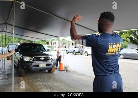 AGAT, Guam (août 13, 2021) - des marins de l'USS Emory S. Land (AS 39) et des Marines du combat Logistics Regiment 17 (CLR-17) se sont portés volontaires au Bureau du maire d'Agat pour distribuer 400 colis de produits alimentaires dans le cadre du Programme d'aide alimentaire d'urgence (PTEAF), août 12. Les produits de base sont rendus possibles par l'intermédiaire du ministère de l'éducation de Guam par l'intermédiaire du Service de nutrition alimentaire du ministère américain de l'Agriculture et sont distribués par les maires des villages aux familles dans le besoin et touchées par la pandémie COVID-19. Le 9 août, des bénévoles du Land et du CLR 17 ont emballé les 400 sacs de nourriture Banque D'Images