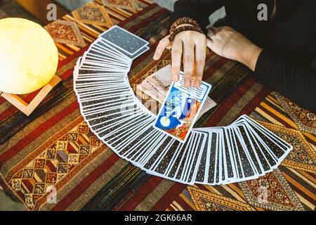 fortune teller utilisant des cartes de tarot et de l'argent thaïlandais sur fond de table Banque D'Images