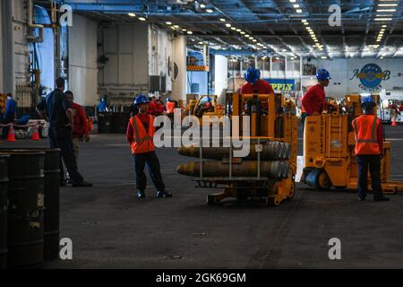 210813-N-MQ631-1050 OCÉAN ATLANTIQUE (AOÛT 13, 2021) les marins transportent des munitions dans la baie hangar du porte-avions de la classe Nimitz USS Harry S. Truman (CVN 75). Truman mène une formation sur la préparation à l'état de préparation dans l'océan Atlantique en vue des opérations futures. Banque D'Images