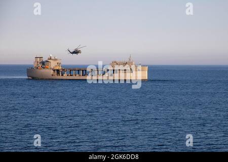 210813-N-LR905-1358 OCÉAN PACIFIQUE (AOÛT 13, 2021) – un Faucon de mer MH-60S, affecté à l'Escadron de combat de la mer (HSC) 23, survole la base maritime expéditionnaire USS Miguel Keith (ESB 5), août 13. HSC 23 est actuellement embarqué à bord de Miguel Keith, qui effectue des opérations de routine dans la 3e flotte des États-Unis. Banque D'Images