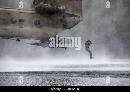 Un ingénieur de combat de l'Armée de terre de la Breacher Company, 6e Brigade Engineer Battalion (Airborne), 4e Brigade de combat d'infanterie (Airborne), 25e division d'infanterie, U.S. Army Alaska, saute d'un CH-47 Chinook pendant l'entraînement d'héliocast à Clunie Lake, base interarmées Elmendorf-Richardson, Alaska, 17 août 2021. Les ingénieurs de combat ont mené les opérations d'hélicast pour établir la confiance et se familiariser avec la formation qu'ils rencontreront lors de leur prochain cours de leadership Sapper. Des aviateurs de l'armée du 2e Bataillon, 211e Régiment d'aviation, de la Garde nationale de l'Armée de l'Alaska, ont fourni un appui aérien pour Banque D'Images