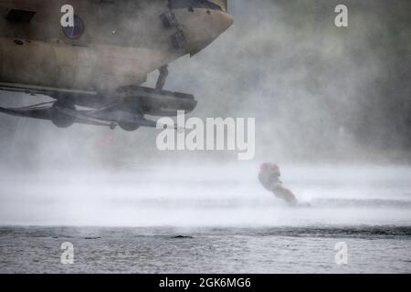 Un ingénieur de combat de l'Armée de terre de la Breacher Company, 6e Brigade Engineer Battalion (Airborne), 4e Brigade de combat d'infanterie (Airborne), 25e division d'infanterie, U.S. Army Alaska, saute d'un CH-47 Chinook pendant l'entraînement d'héliocast à Clunie Lake, base interarmées Elmendorf-Richardson, Alaska, 17 août 2021. Les ingénieurs de combat ont mené les opérations d'hélicast pour établir la confiance et se familiariser avec la formation qu'ils rencontreront lors de leur prochain cours de leadership Sapper. Des aviateurs de l'armée du 2e Bataillon, 211e Régiment d'aviation, de la Garde nationale de l'Armée de l'Alaska, ont fourni un appui aérien pour Banque D'Images