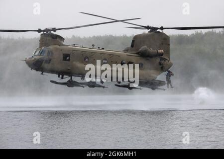 Un ingénieur de combat de l'Armée de terre de la Breacher Company, 6e Brigade Engineer Battalion (Airborne), 4e Brigade de combat d'infanterie (Airborne), 25e division d'infanterie, U.S. Army Alaska, saute d'un CH-47 Chinook pendant l'entraînement d'héliocast à Clunie Lake, base interarmées Elmendorf-Richardson, Alaska, 17 août 2021. Les ingénieurs de combat ont mené les opérations d'hélicast pour établir la confiance et se familiariser avec la formation qu'ils rencontreront lors de leur prochain cours de leadership Sapper. Des aviateurs de l'armée du 2e Bataillon, 211e Régiment d'aviation, de la Garde nationale de l'Armée de l'Alaska, ont fourni un appui aérien pour Banque D'Images