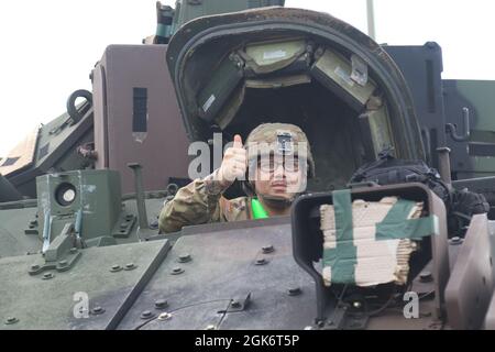 Un soldat du 1er Bataillon, 64ème Régiment d'armure, 1re équipe de combat de la Brigade blindée, 3e Division d'infanterie, donne un pouce alors qu'il se prépare à charger un véhicule de combat Bradley dans la zone de marécagissement du fort Stewart, en Géorgie, le 18 août 2021. Les soldats du Raider ont reçu leur équipement après un déploiement réussi de 9 mois en République de Corée. Banque D'Images