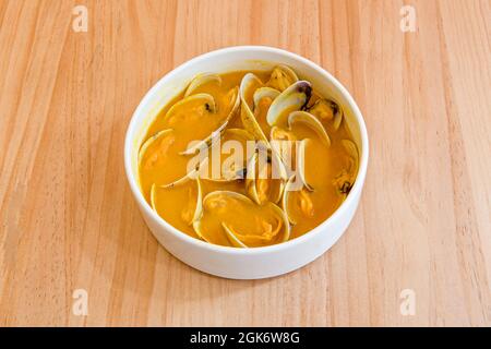 bol de tapa de palourdes en sauce marine sur table en bois de couleur miel Banque D'Images