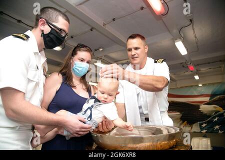 Cmdr. Lt. Michael Matson, un aumônier affecté au département des ministères religieux de l’USS Gerald R. Ford (CVN 78) et originaire de Minneapolis, baptise le lieutenant Matthew Dennis et le fils de sa femme dans le FO’Selle du navire, le 18 août 2021. Dennis est l’adjoint à la propulsion de maintenance du département des réacteurs de Ford et est originaire d’Elkton, Maryland. Ford est dans le port de la base navale de Norfolk en préparation de sa transition vers Newport News pour une disponibilité progressive prévue. Banque D'Images