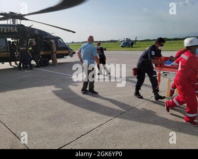 Douanes et protection des frontières agents des opérations aériennes et maritimes transportant des citoyens haïtiens blessés en Haïti, le 19 août 2021. La Garde côtière et les agences partenaires continuent de mener des opérations en cours en Haïti en transportant du personnel médical et en évacuant ceux qui ont besoin de soins de plus haut niveau. Banque D'Images