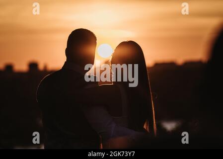 Silhouette de couple sur fond de coucher de soleil. Banque D'Images