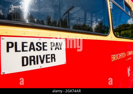 Veuillez payer le panneau du chauffeur sur le côté d'un bus d'époque, Winchester, Royaume-Uni Banque D'Images