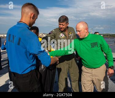 210820-N-OH958-1506 PORTSMOUTH, Virginie (20 août 2021) Capt Robert Aguilar, commandant du porte-avions USS George H. W. Bush (CVN 77), Middle, et Cmdr. Anthony Banister, l'agent d'approvisionnement de GHWB, participe à un déplacement de débris d'objets étrangers (FOD) à bord du porte-avions USS George H. W. Bush (CVN 77). GHWB est sur le point d'achever une disponibilité incrémentielle prévue pour l'amarrage au chantier naval de Norfolk. Banque D'Images