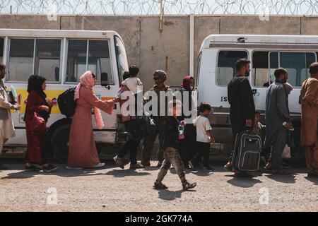 210822-M-TU241-1012 AÉROPORT INTERNATIONAL HAMID KARZAÏ (Afghanistan) (22 août 2021) les évacués chargent des bus devant être traités lors d'une évacuation à l'aéroport international Hamid Karzaï, Kaboul (Afghanistan), le 22 août. Les membres du service américain aident le ministère d'État à effectuer une opération d'évacuation non combattantes (NEO) en Afghanistan. Banque D'Images