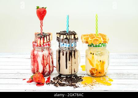 délicieux smoothies aux fruits et au chocolat. Maracuya avec gaufres, gâteau au chocolat et sirop, cheesecake avec baies et fraises Banque D'Images