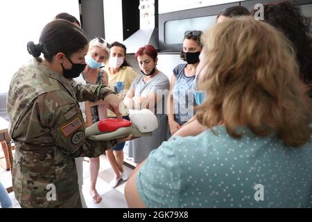 Le capitaine de l'armée américaine Kaitlin Cugno, commandant de la Force opérationnelle médicale du Commandement régional de la KFOR pour l'est (RC-E), montre comment effectuer un RCP infantile à l'aide d'un mannequin médical pour les civils locaux à Gjilan, au Kosovo, le 23 août 2021. Des soldats de l'armée américaine de la Force opérationnelle médicale de la KFOR RC-E et d'autres unités de soutien ont collaboré avec une femme 4 de l'organisation non gouvernementale (W4W) pour diriger une session de familiarisation au RPC pour les nourrissons et les enfants à l'intention des femmes locales. Banque D'Images