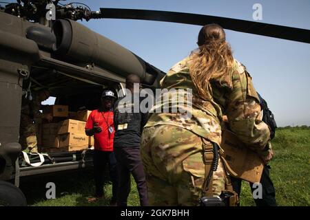 Des gardes de l'aviation de la Garde nationale de l'armée de Porto Rico aident le personnel de l'USAID à charger des vivres dans l'hélicoptère UH-60, Port-au-Prince, Haïti, le 24 août 2021. Les dispositions étaient destinées à la communauté de Jeremie, Haïti, le 24 août 2021. Banque D'Images