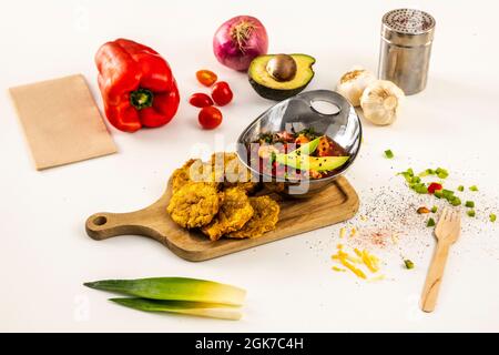 bol à ragoût de crevettes avec avocat et patacon. ail et oignons, poivrons rouges et tomates cerises sur table blanche Banque D'Images