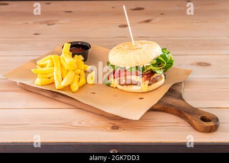 Hamburger de bœuf au fromage fondu, une tranche de jambon ibérique, de la laitue d'agneau, de la mayonnaise et des frites maison Banque D'Images