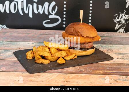 Hamburger de bœuf double mélangé avec du schnitzel de poulet et des frites Banque D'Images