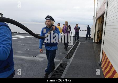 Le 25 août 2021, les membres d'équipage du Cutter Healy (WAWB 20) de la Garde côtière ont mis en place un tuyau à carburant lors des opérations d'entraînement en vol dans le golfe d'Alaska. L'équipage a utilisé le tuyau pour fournir du carburant à l'équipage d'un hélicoptère Dolphin Kodiak MH-65 de la station aérienne pendant la formation aux opérations de vol conjointes. Banque D'Images