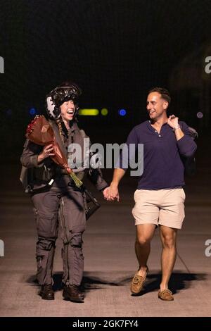 Le capitaine Anneliese Satz, un pilote F-35 de l'escadron d'attaque de chasseurs de Marines (VMFA) 121, marche avec le capitaine Anthony Pompei à son retour à la station aérienne du corps de Marines Iwakuni, au Japon, le 25 août 2021. SATZ et d'autres Marines affectés à l'escadron ont été déployés avec la 31e unité expéditionnaire maritime pour soutenir l'exercice Talisman Sabre. Cet exercice semestriel est la plus importante activité d'entraînement mixte bilatérale entre la Force de défense australienne et l'armée américaine. Banque D'Images