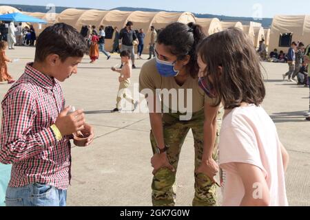 Armée américaine 1er lieutenant Neha Sharma, 66e officier du renseignement de la brigade militaire de l'armée américaine Garrison Wiesbaden, parle aux enfants à la base aérienne de Ramstein, en Allemagne, le 25 août 2021. Sharma s'est porté volontaire pour aider dans le hangar féminin pendant l'opération alliés refuge. Banque D'Images