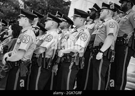 Les membres de la police du parc des États-Unis écoutent le général de division Allan M. Pepin (non représenté), commandant général de la Force opérationnelle interarmées de la région de la capitale nationale et du quartier militaire de l'armée américaine de Washington sur les marches ouest de l'amphithéâtre commémoratif du cimetière national d'Arlington, Arlington, Virginie, le 26 août 2021. Banque D'Images