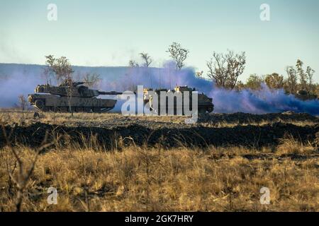 Un char de combat principal australien M1A1 Abrams et un transporteur de personnel blindé M113AS4 se déplacent vers objective Crocodile pour les répétitions pendant l'exercice Koolendong à la zone d'entraînement de Bradshaw Field, territoire du Nord, Australie, 26 août 2021. Les soldats américains des Marines et de l'armée australienne ont participé à des attaques montées et démontées pendant l'exercice. Des exercices comme Koolendong valident la capacité de la Marine Rotational Force-Darwin et de la Défense australienne à mener des opérations expéditionnaires avancées avec des capacités innovantes combinées ; et par leur engagement commun, sont prêts à répondre à un crisi Banque D'Images