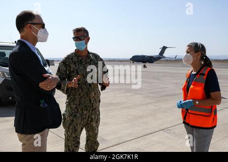 STATION NAVALE AÉRIENNE DE SIGONELLA, Italie (août 27, 2021) – Thomas Smitham, chargé d'affaires ambassade des États-Unis à Rome, à gauche, écoute le capitaine Kepper Pickard, commandant de la base aérienne navale de Sigonella, au centre, et Kimberly Krhounek, ministre politique Conseiller, ambassade des États-Unis à Rome, Tout comme ils expliquent le processus de réception des évacués d'Afghanistan à NAS Sigonella, le 27 août 2021. NAS Sigonella appuie actuellement la mission du département d'État visant à faciliter le départ et la réinstallation en toute sécurité des citoyens américains, des bénéficiaires de visas d'immigration spéciaux et des populations vulnérables d'Afghanistan. Banque D'Images