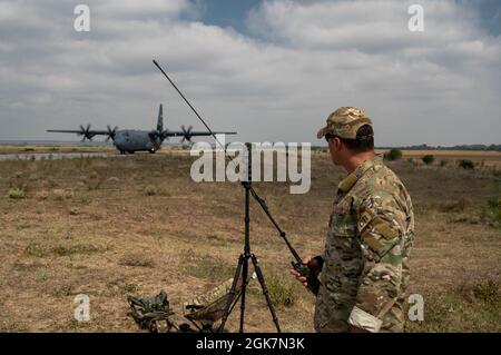 U.S. Air Force Tech. Sgt. James Supernault, 435e Escadron d'intervention en cas de contingence, observe un C-130J Super Hercules qui débarque sur l'autoroute Poroyna en Bulgarie pendant l'été 2021 de Thrace, le 27 août 2021. Le 435e CS ex facilite l'événement en marquant les limites de la route modifiée, en communiquant les conditions météorologiques et en arpentant les terres afin de déterminer les conditions d'atterrissage adéquates. Banque D'Images