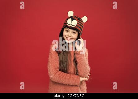 joyeux enfant dans des vêtements chauds d'hiver en tricot et chapeau à rabats prêt pour les activités de vacances, mode d'hiver Banque D'Images