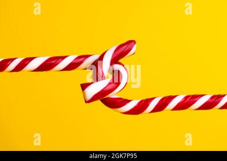 Sucettes de canne à sucre sur fond jaune, bonbons de Noël. Banque D'Images