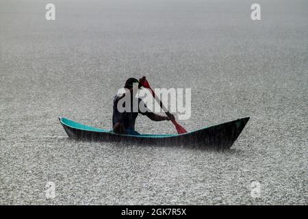 PORTOBELO, PANAMA - 28 MAI 2016 : homme local dans son canoë lors d'une forte pluie. Banque D'Images