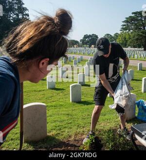 Qoucela Marniche, technicien en électronique de 2e classe, de Cherry Hill, New Jersey, à droite, affecté au porte-avions USS John C. Stennis (CVN 74), répand le sol autour des fleurs nouvellement plantées lors d'un événement bénévole du Service des ministères religieux du Commandement (CRMD), au complexe du cimetière national de Hampton, à Hampton, en Virginie, le 28 août 2021. John C. Sennis est à Newport News Shipyard travaillant aux côtés de NNS, de NAVSEA et d'entrepreneurs effectuant le ravitaillement et la révision complexe dans le cadre de la mission de livrer le navire de guerre dans le combat, dans les délais et dans le budget, pour reprendre son devoir de défendre le Banque D'Images