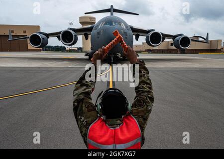 Le principal Airman Elijah Turner, chef d'équipage du 911e Escadron de maintenance d'aéronefs, signale à l'équipage d'un C-17 Globemaster III de s'arrêter à la place de stationnement désignée sur la ligne de vol à la station de réserve aérienne de l'aéroport international de Pittsburgh, en Pennsylvanie, le 31 août 2021. Le stationnement de l'avion a marqué la fin des efforts d'évacuation en Afghanistan pour les membres de la 911e Escadre du transport aérien. Banque D'Images