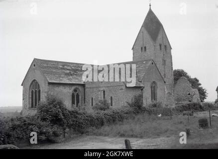 1962, vue historique de cette époque de l'église St Mary à Sompting, Littlehampton, West Sussex, Angleterre, Royaume-Uni. 1962, le bâtiment de l'église construit à silex, avec sa tour saxonne, a été classé comme Grade I par le patrimoine anglais en 1954, en raison de son importance historique exceptionnelle, en particulier la barre rhénane sur la tour de l'église, avec son chapeau à quatre côtés de style pyramide à pignons très inhabituel en Angleterre. Banque D'Images