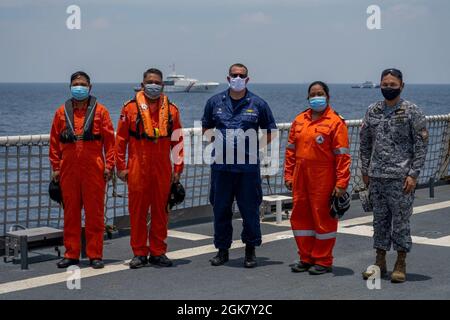 Le commandant du Cutter de la Garde côtière américaine Munro, le capitaine Blake Novak, et les membres de la Garde côtière des Philippines se tiennent sur le pont du Munro, dans la mer des Philippines-Ouest, le 31 août 2021. Les membres de la Garde côtière à bord du Munro et de la Garde côtière des Philippines ont participé à des opérations et exercices bilatéraux qui comprenaient des exercices de sensibilisation au domaine maritime et des opérations de petits bateaux. Banque D'Images