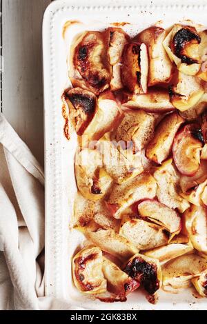 Tranches de pomme cuites à la cannelle dans un plat de cuisson. Banque D'Images