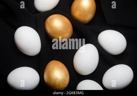 Œuf doré parmi les œufs blancs fond noir. L'idée conceptuelle des récompenses financières sur le régime de retraite. Banque D'Images