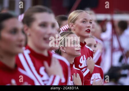 BLOOMINGTON, ÉTATS-UNIS - 2021/09/11: Les leaders de l'université de l'Indiana placent leurs mains sur leur cœur pendant le jeu de l'hymne national à l'anniversaire de l'attaque de 9/11 avant que l'université de l'Indiana ne joue contre l'Idaho lors d'un match de football de la NCAA le 11 septembre 2021 au Memorial Stadium à Bloomington, dans l'Indiana. The Hoosiers battit les Vandales 56-14. Banque D'Images