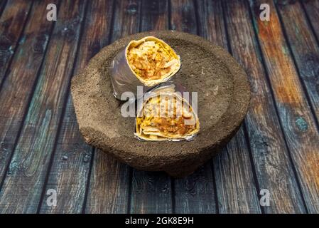 Piment mexicain con carne burrito enveloppé dans du papier aluminium sur de la pierre volcanique molcajete Banque D'Images