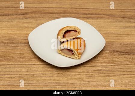 Cachito vénézuélien farci de jambon et de fromage frais sur la plaque blanche. Petit déjeuner vénézuélien Banque D'Images