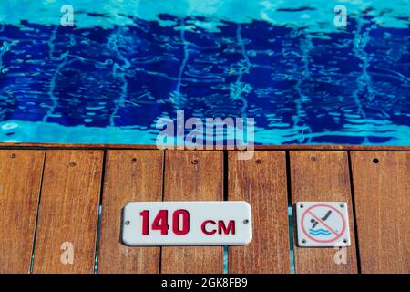 pas de plongée et de signe d'avertissement de profondeur au bord de la piscine avec l'espace de copie Banque D'Images