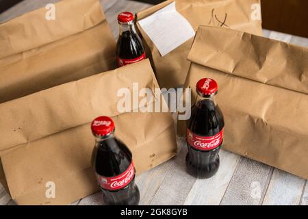 Dnepropetrovsk, Ukraine - 08.05.2021: Sacs en papier avec nourriture et bouteilles de cola livrés à votre maison pendant la période d'auto-isolation. Banque D'Images