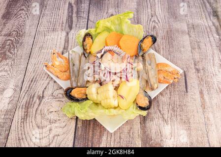 Ceviche péruvienne typique du bar avec fruits de mer, crevettes, pétoncles, palourdes du rasoir, moules et marinés avec oignon rouge, poivrons, lime, cancha, ciboulette et Banque D'Images