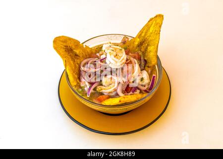 bol en verre orange avec crevettes, oignon rouge et plantain pour la vinaigrette Banque D'Images